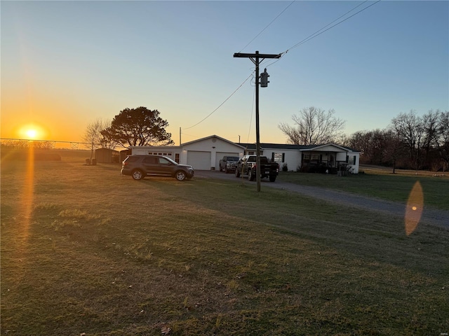 view of front facade featuring a garage, an outbuilding, and a yard