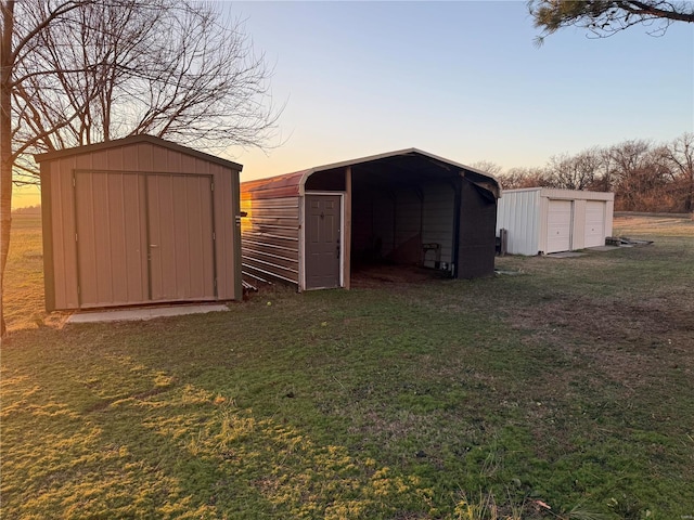 outdoor structure at dusk with a carport and a lawn