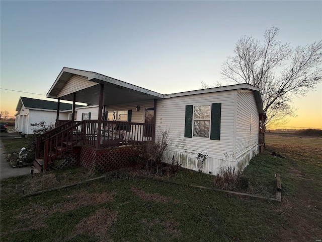 manufactured / mobile home with a lawn and covered porch