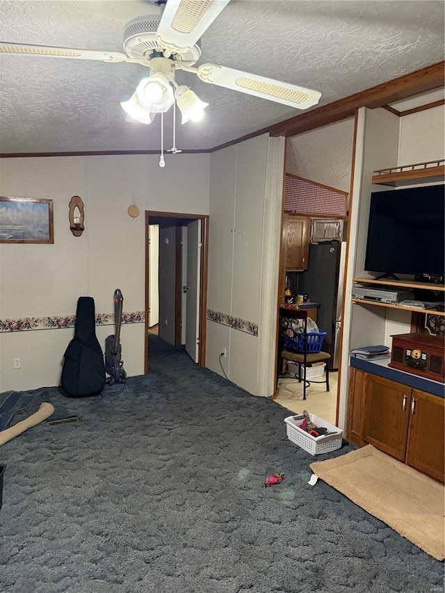 interior space featuring ceiling fan, a textured ceiling, and ornamental molding