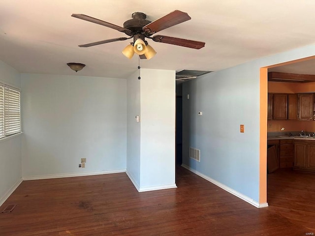 unfurnished room featuring ceiling fan, dark hardwood / wood-style flooring, and sink