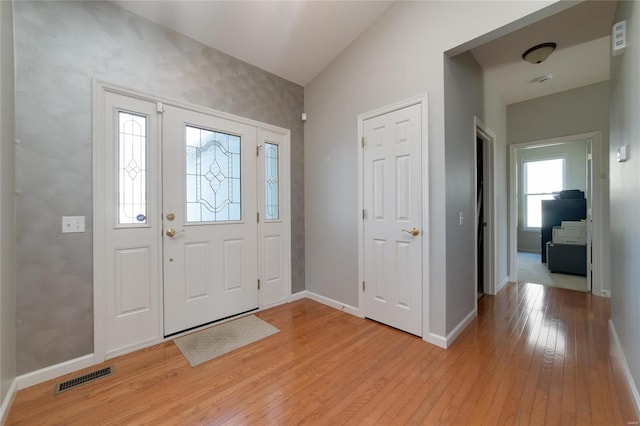 foyer with vaulted ceiling and light hardwood / wood-style flooring