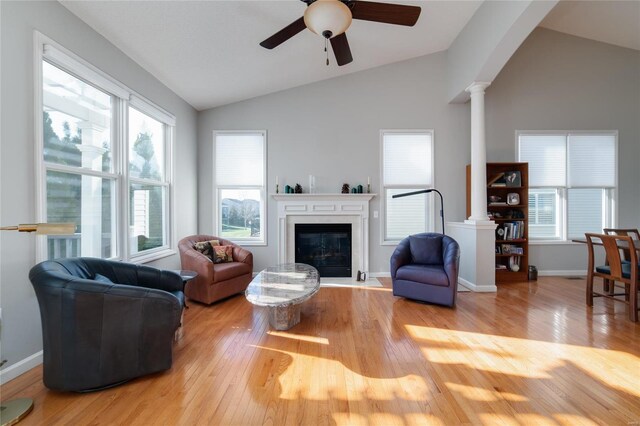 living room with vaulted ceiling, light hardwood / wood-style floors, ceiling fan, and ornate columns