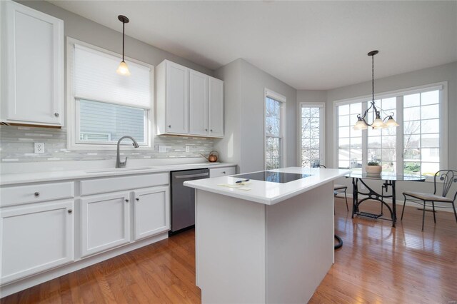 kitchen featuring white cabinetry, sink, decorative light fixtures, and dishwasher