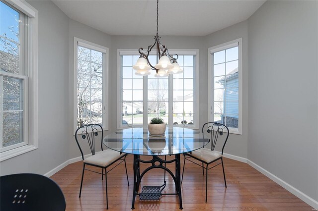 dining space featuring wood-type flooring and a chandelier