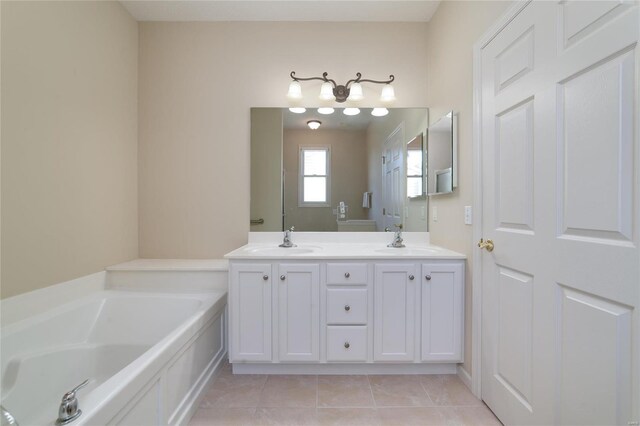 bathroom with tile patterned flooring, vanity, and a bath