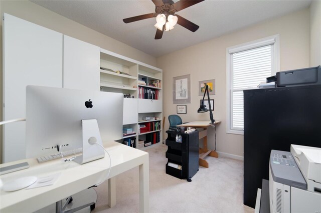 carpeted home office featuring ceiling fan