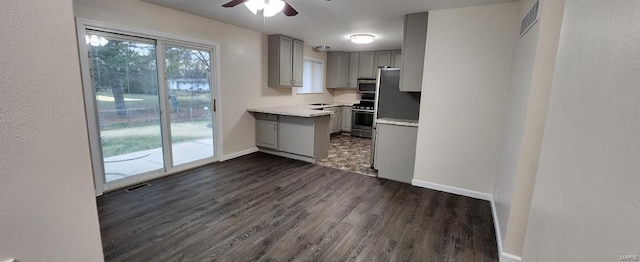 kitchen with gray cabinetry, ceiling fan, dark wood-type flooring, and stainless steel appliances