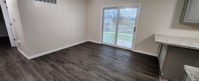 unfurnished dining area featuring dark wood-type flooring