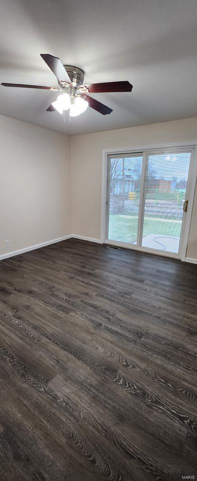 empty room featuring ceiling fan, dark hardwood / wood-style flooring, and a healthy amount of sunlight