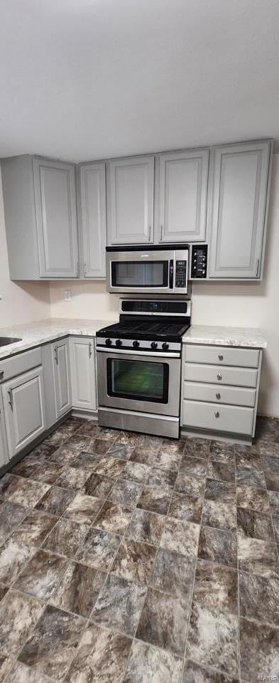 kitchen with gray cabinets, sink, and stainless steel appliances