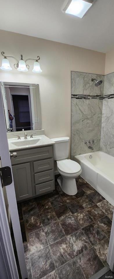 full bathroom with toilet, vanity, and tiled shower / bath combo