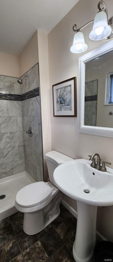 bathroom featuring toilet and tiled shower