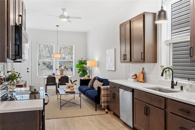 kitchen with sink, hanging light fixtures, decorative backsplash, appliances with stainless steel finishes, and dark brown cabinets