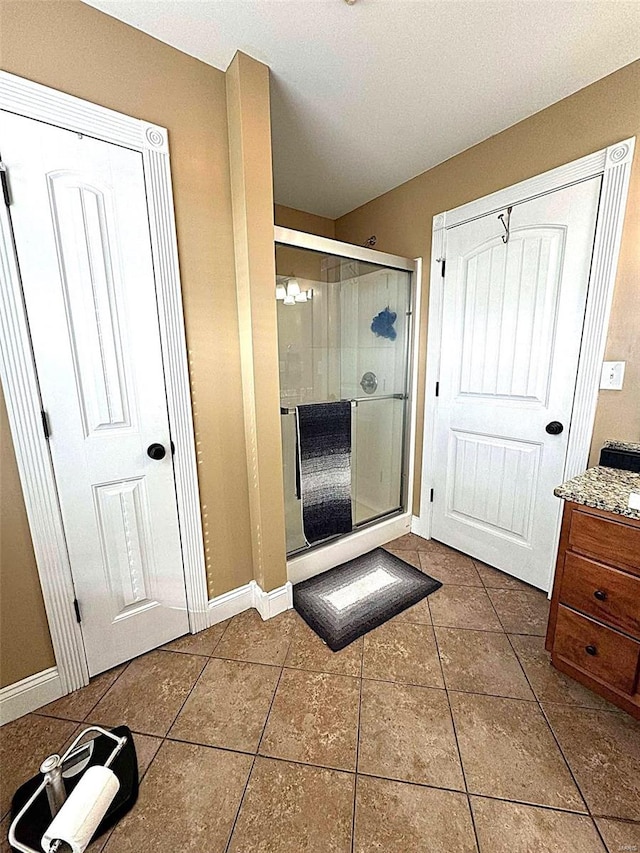 bathroom with tile patterned flooring, vanity, and a shower with shower door