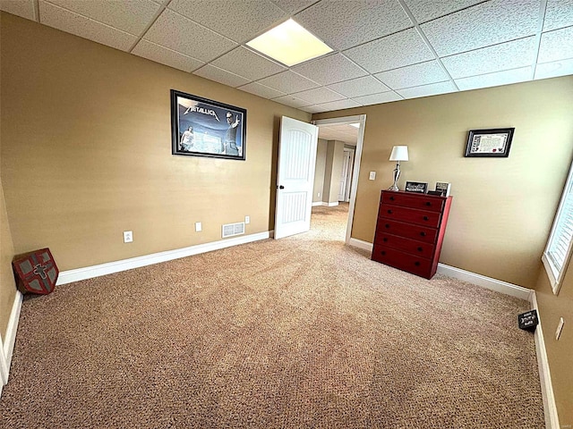 unfurnished bedroom featuring carpet and a paneled ceiling