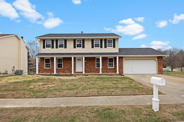 colonial-style house featuring a front yard, a porch, and a garage