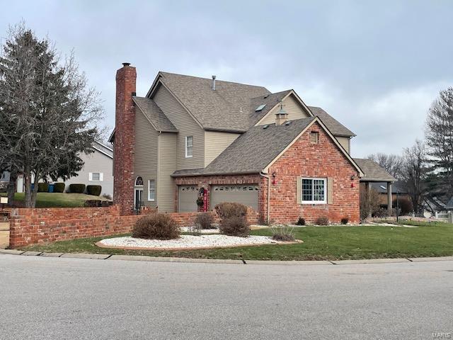 view of front of home with a garage and a front lawn