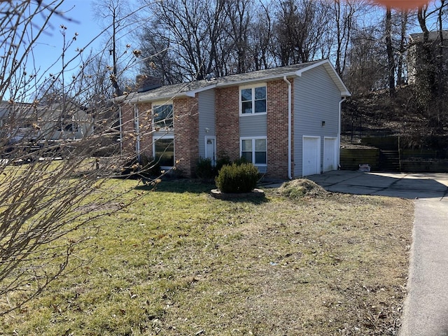 view of front of property featuring concrete driveway, a chimney, an attached garage, a front lawn, and brick siding