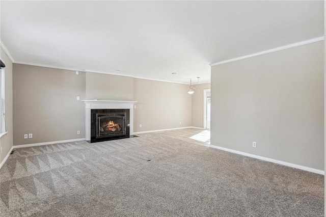 unfurnished living room featuring baseboards, carpet floors, a tile fireplace, and crown molding