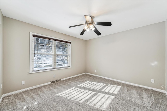 unfurnished room featuring ceiling fan, carpet, visible vents, and baseboards