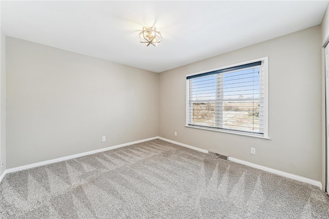 carpeted empty room with visible vents and baseboards