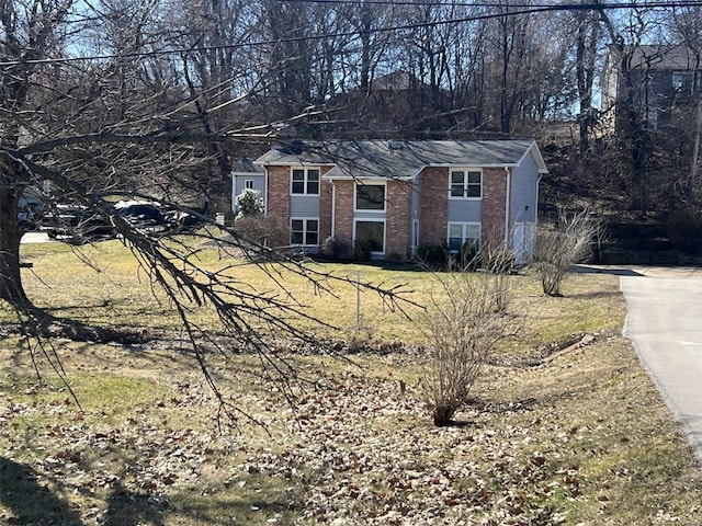 view of front of house with a front yard and brick siding