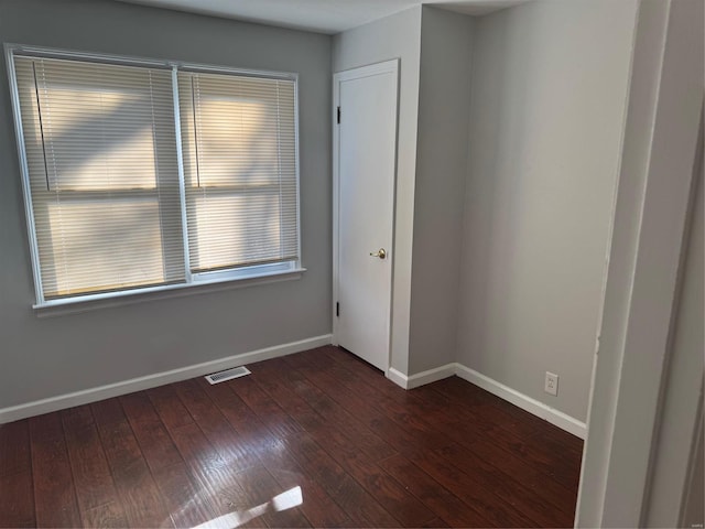 spare room featuring dark wood-type flooring