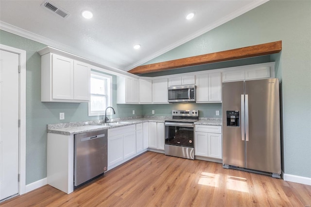 kitchen featuring sink, light hardwood / wood-style flooring, vaulted ceiling, white cabinets, and appliances with stainless steel finishes