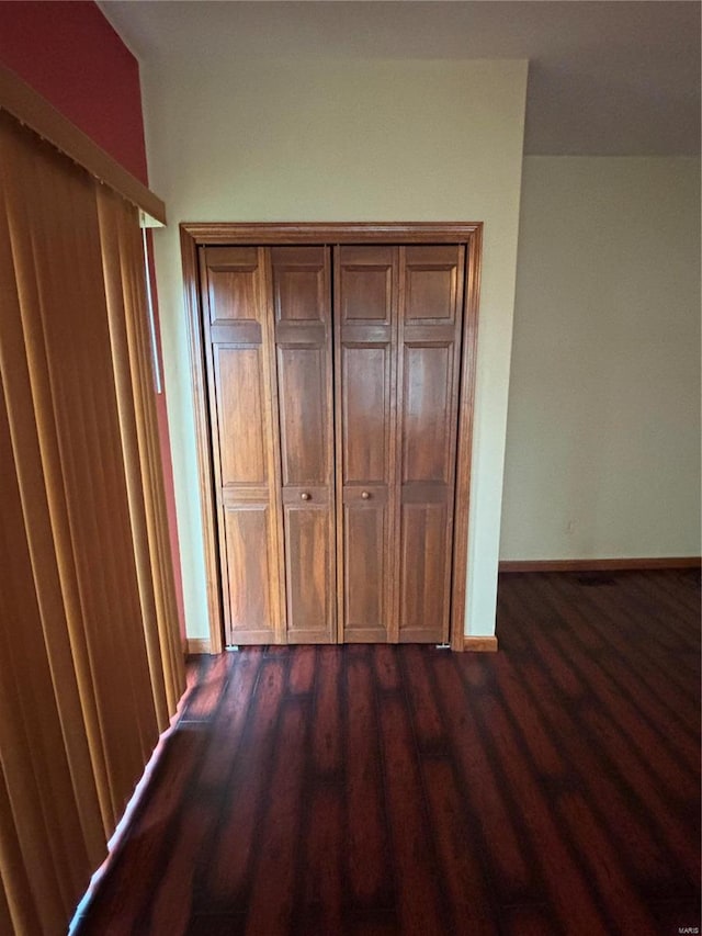 unfurnished bedroom with dark wood-type flooring