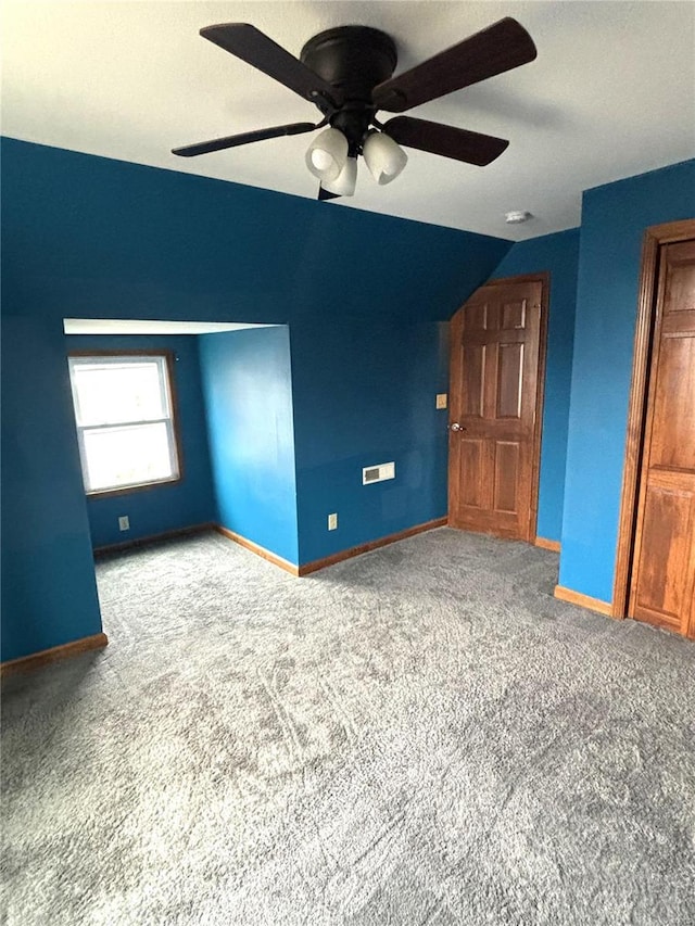 empty room featuring ceiling fan, lofted ceiling, and carpet floors