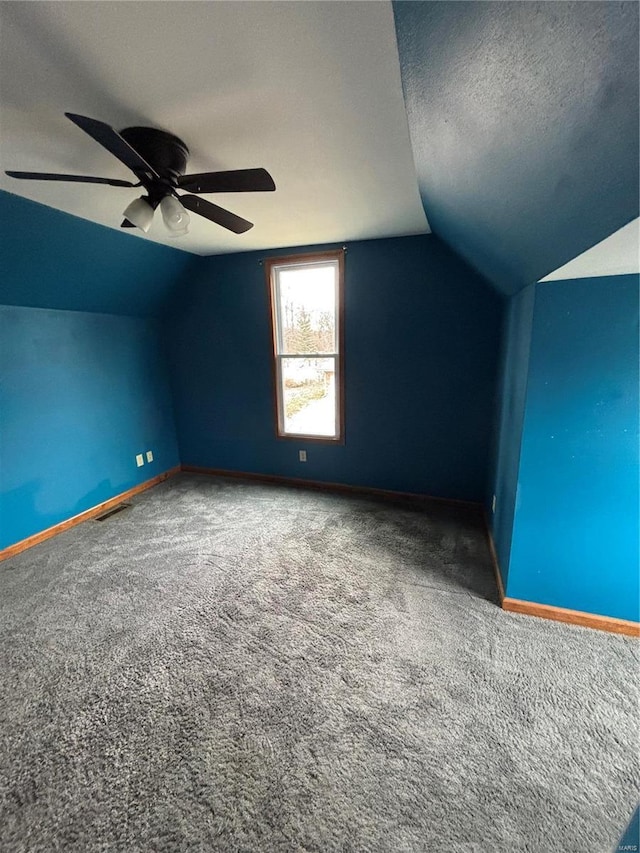 additional living space featuring carpet, a textured ceiling, vaulted ceiling, and ceiling fan