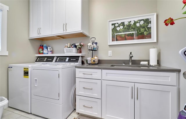 laundry area featuring light tile patterned floors, sink, washing machine and clothes dryer, and cabinets