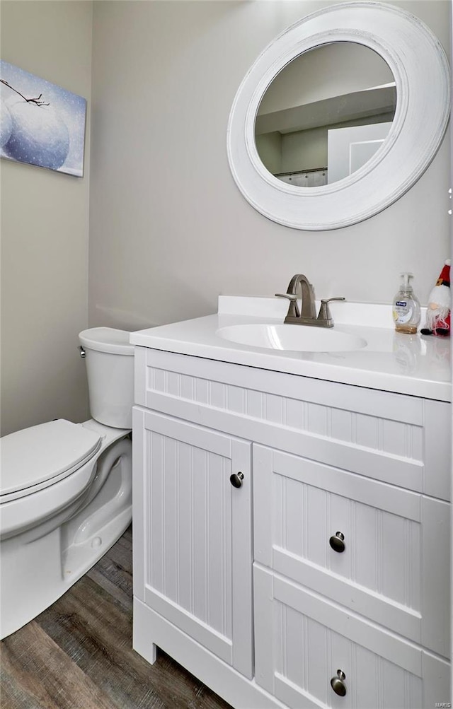 bathroom featuring toilet, vanity, and wood-type flooring