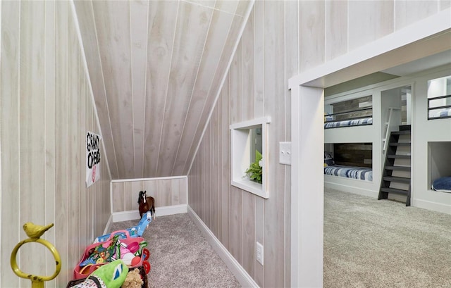 rec room featuring lofted ceiling, carpet, wood ceiling, and wooden walls