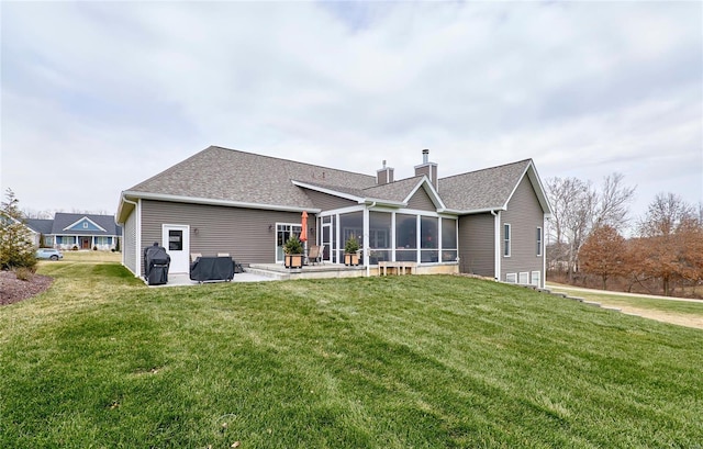 rear view of house with a yard, a patio, and a sunroom