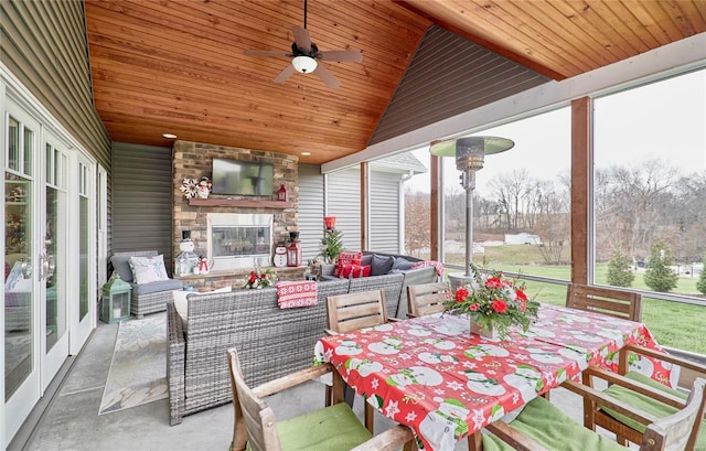 sunroom / solarium featuring vaulted ceiling, ceiling fan, and wood ceiling