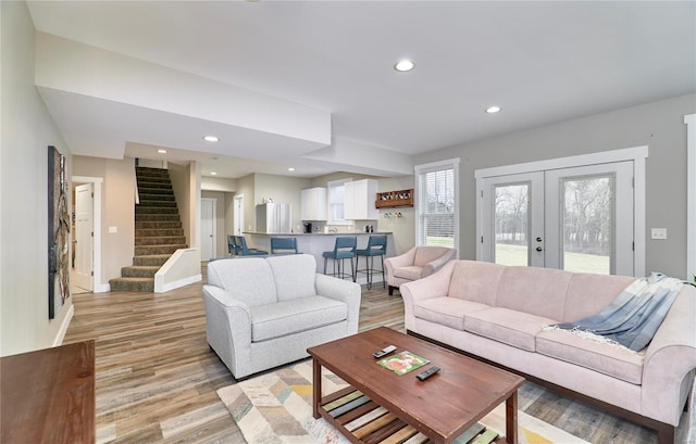 living room with light hardwood / wood-style flooring and french doors