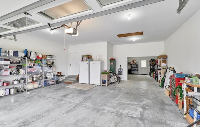 garage with a garage door opener and white refrigerator