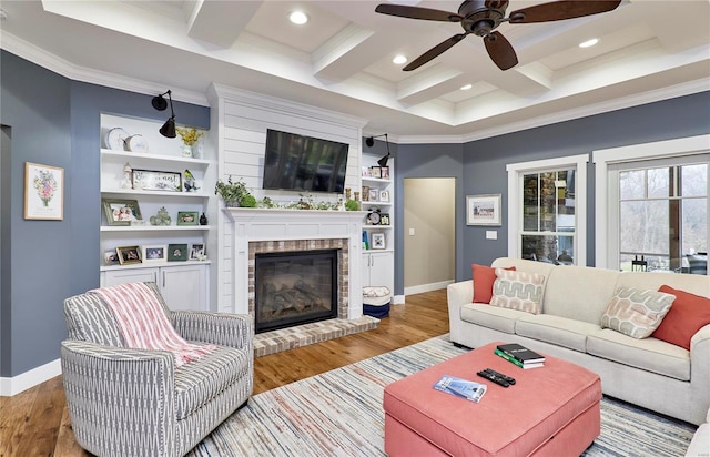 living room with coffered ceiling, a brick fireplace, beam ceiling, and light hardwood / wood-style flooring