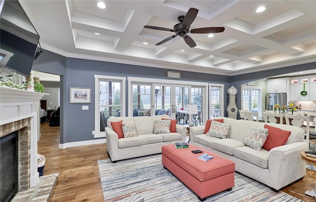 living room with coffered ceiling, beam ceiling, crown molding, light hardwood / wood-style flooring, and a fireplace