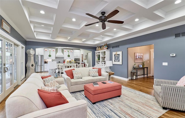 living room with beamed ceiling, light wood-type flooring, and french doors