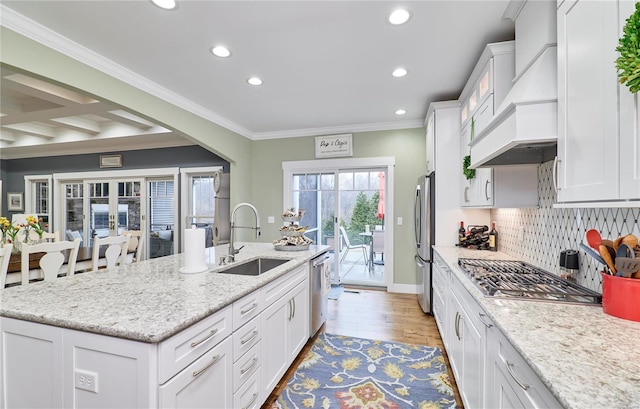 kitchen featuring appliances with stainless steel finishes, white cabinetry, sink, custom exhaust hood, and light stone countertops