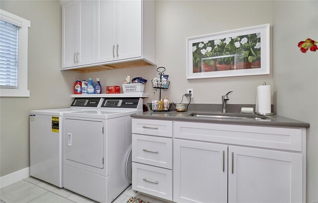 clothes washing area featuring sink, cabinets, washing machine and clothes dryer, and light tile patterned flooring