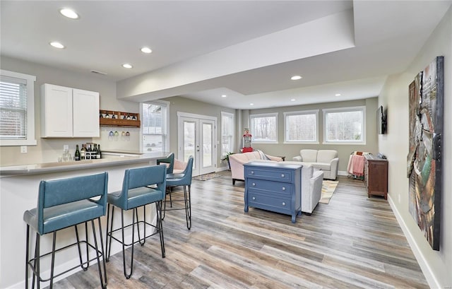 kitchen with blue cabinets, a breakfast bar area, white cabinets, and french doors