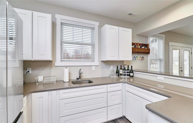 kitchen featuring a healthy amount of sunlight, sink, and white cabinets