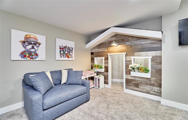 living area featuring vaulted ceiling, carpet floors, and wood walls