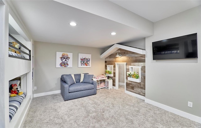 living area featuring carpet floors and wood walls