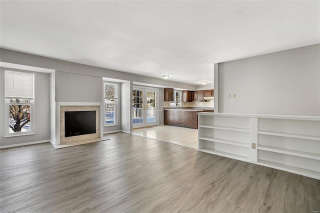 unfurnished living room with french doors and light hardwood / wood-style floors