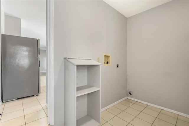 clothes washing area featuring hookup for an electric dryer, light tile patterned floors, and hookup for a washing machine